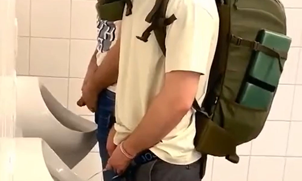 Handsome traveller caught peeing at urinals