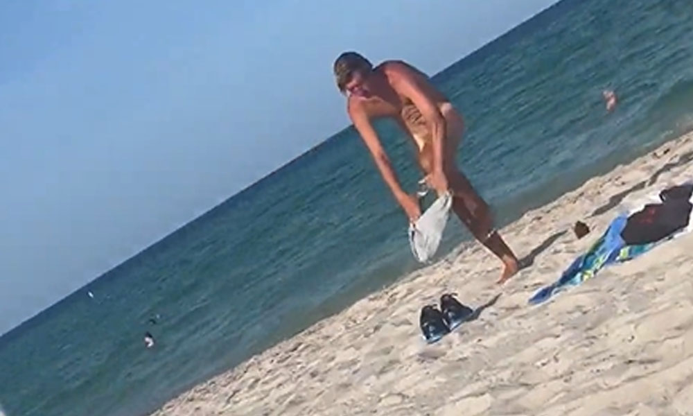 surfer guy changing his speedo at the beach