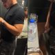 Handsome guy pissing and spitting at urinals